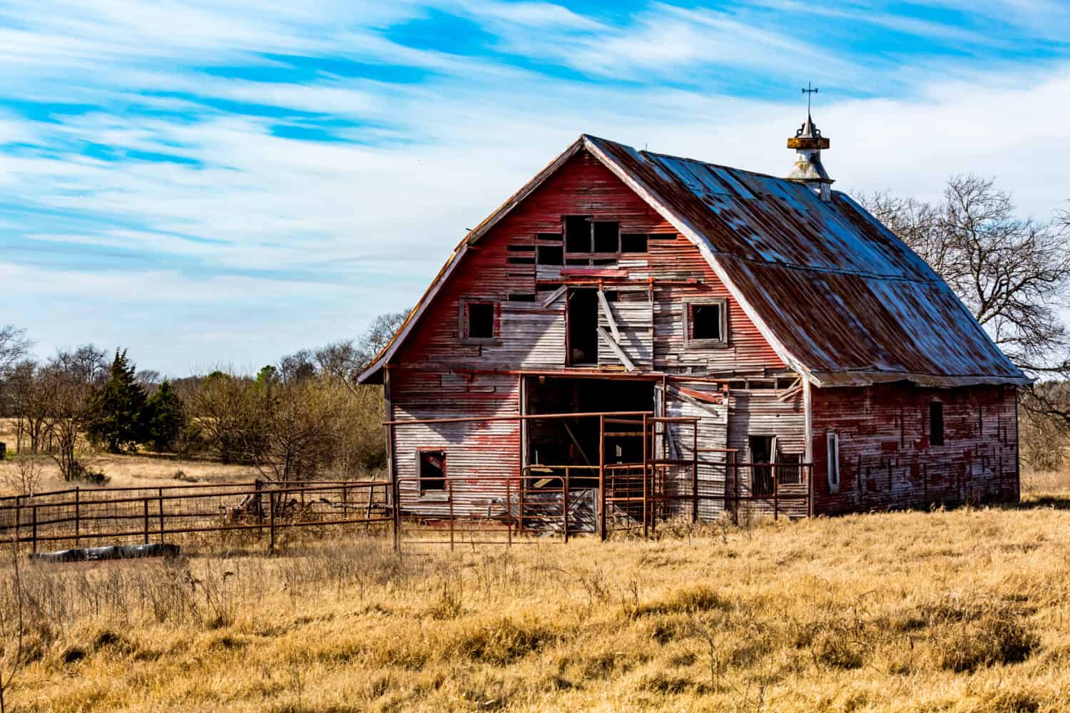 Terreno agricolo rurale dell'Oklahoma con fienile abbandonato o agriturismo.  Uno spettacolo comune nelle città fantasma abbandonate e dimenticate dell'Oklahoma.