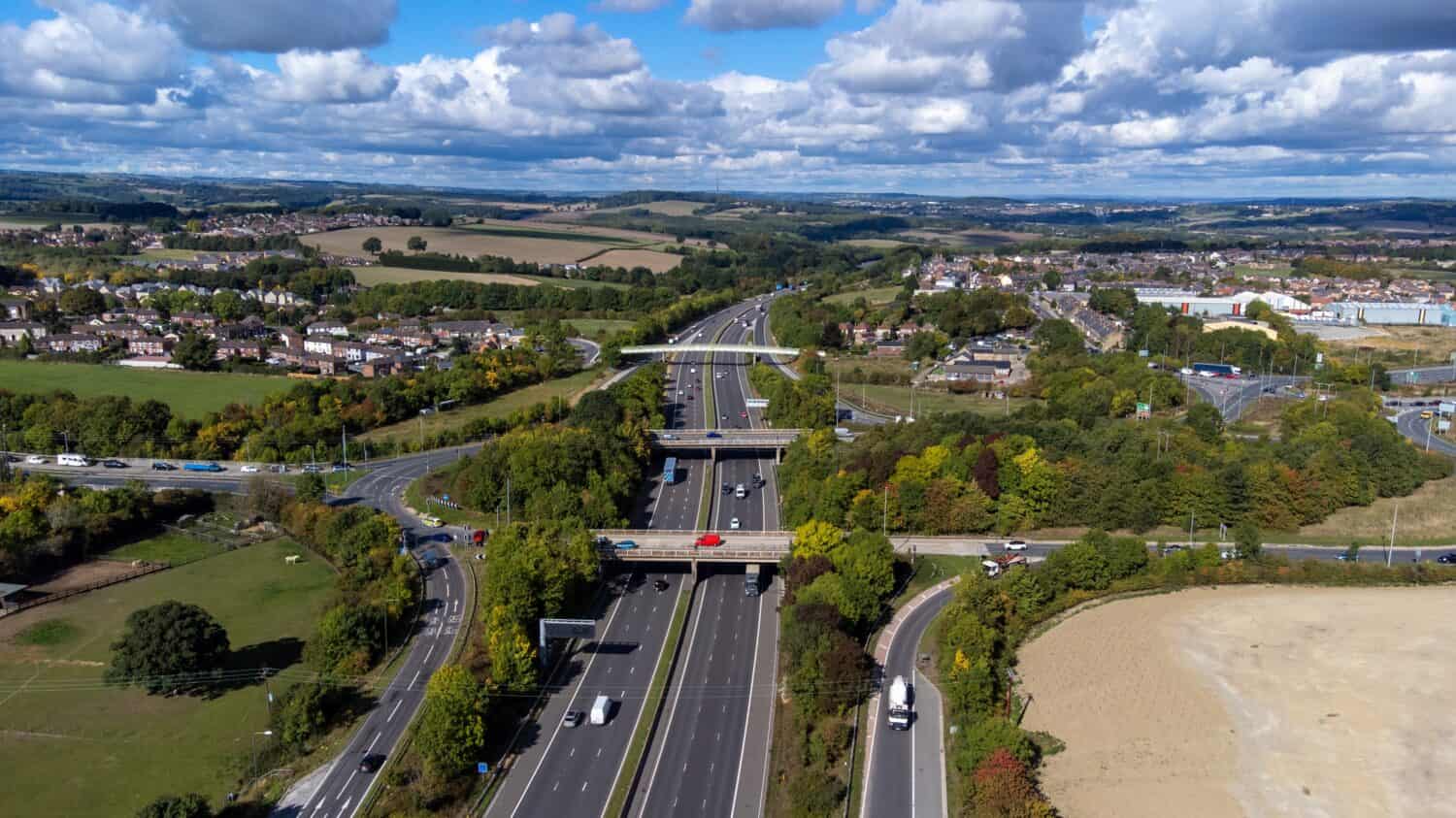 Foto aerea del drone della trafficata autostrada M1 con tre ponti che attraversano l'autostrada nel villaggio di Barnsley a Sheffield UK in estate in una luminosa giornata estiva.