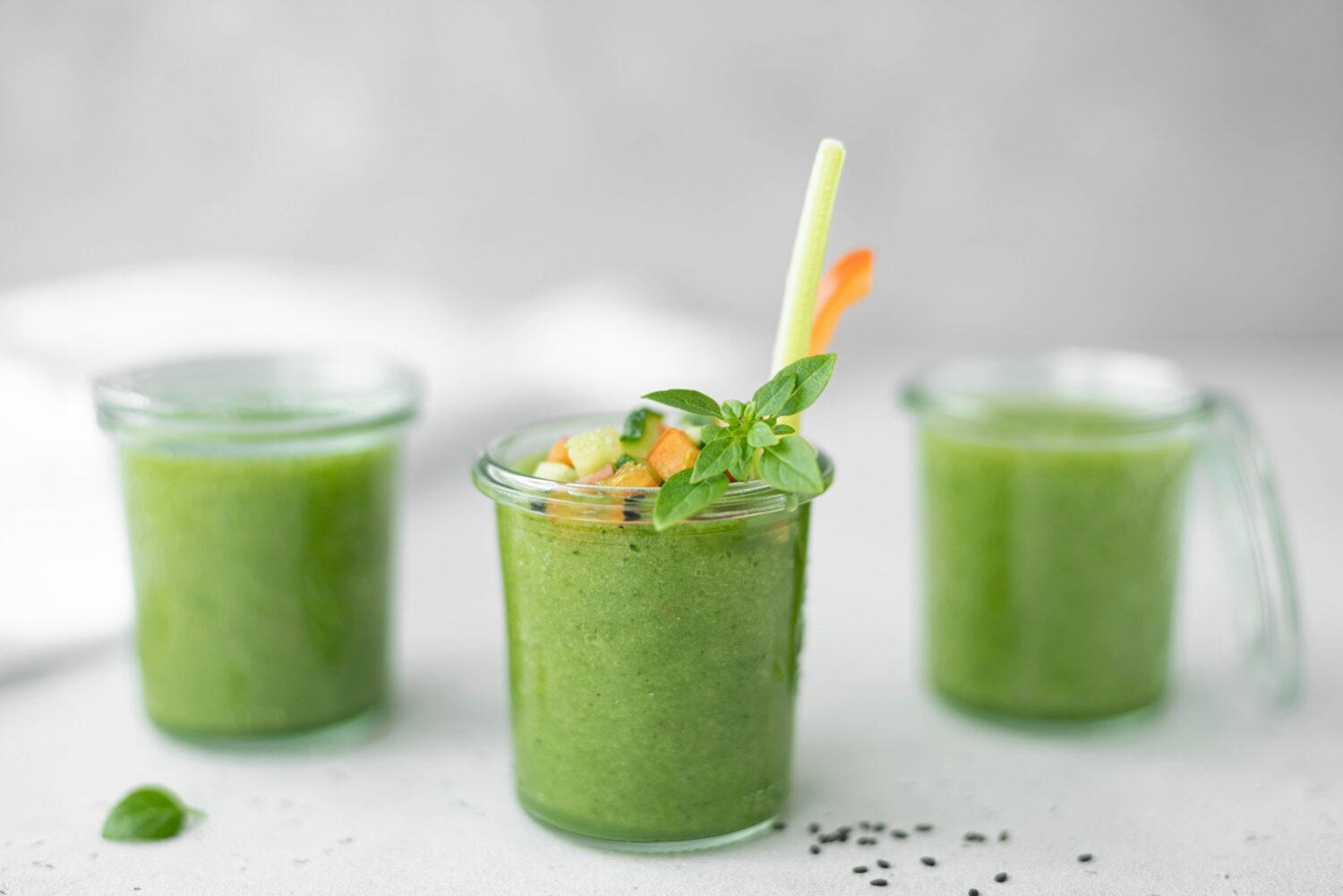 gazpacho di cetriolo freddo con sedano, pomodoro e basilico in un bicchiere, primo piano