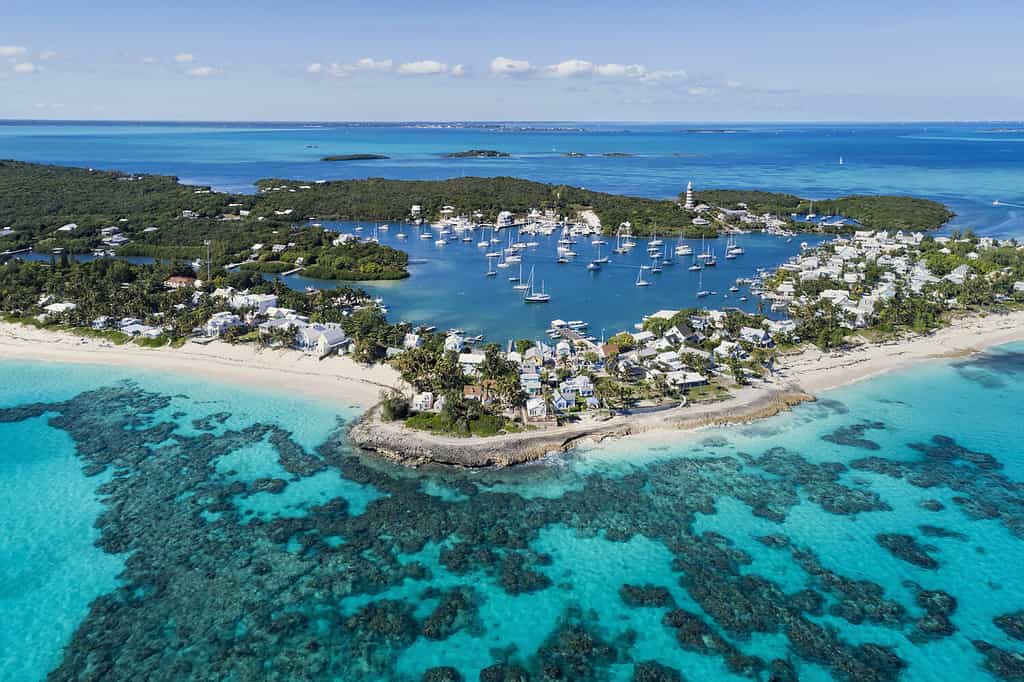 Vista aerea del porto, della spiaggia e del faro di Hope Town su Elbow Cay al largo dell'isola di Abaco, Bahamas.