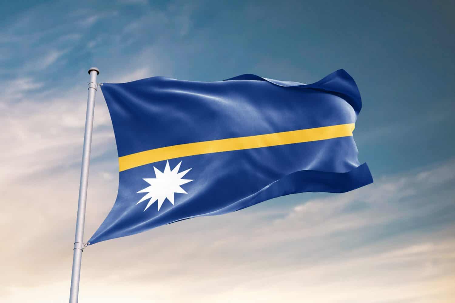 Sventola bandiera di Nauru nel bel cielo.  Bandiera Nauru per il giorno dell'indipendenza.  Il simbolo dello stato su tessuto ondulato.
