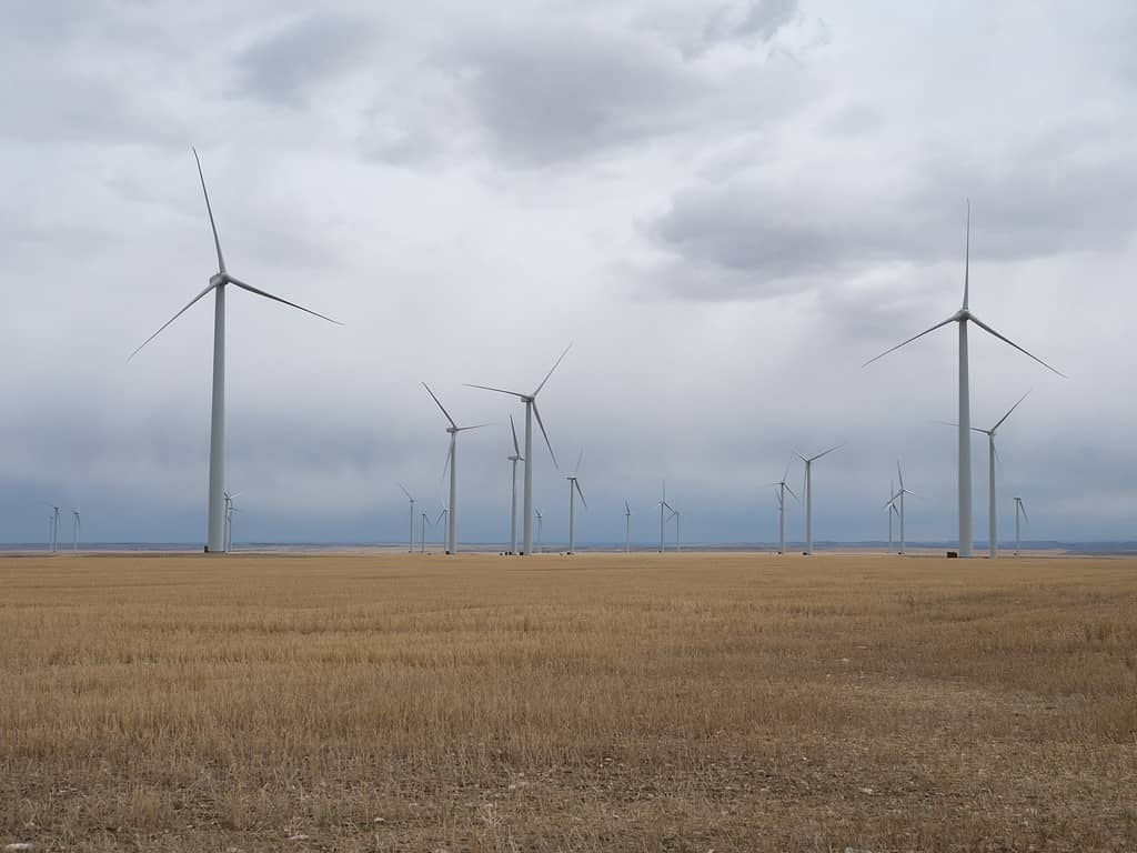 Parco eolico Montana con turbine eoliche in un campo agricolo e nuvole temporalesche sopra