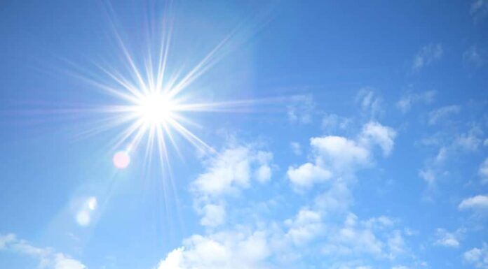 Cielo blu con soffici nuvole bianche e riflesso del sole.  Leggi per conoscere la temperatura più calda del Connecticut.