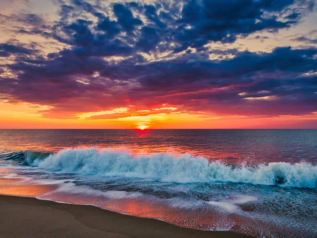 Alba dalla spiaggia di Bethany, Delaware, con spettacolare skycap e surf.
