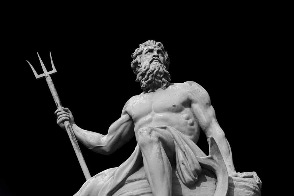 Il potente dio del mare e degli oceani Nettuno (Poseidone) L'antica statua isolata su sfondo nero.