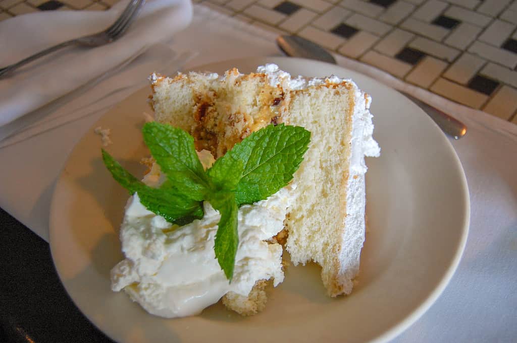 Una spessa fetta di torta Lane, che racchiude un ripieno agrodolce fruttato tra strati di torta leggerissima alla vaniglia.