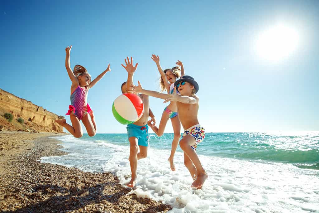 Bambini carini che si divertono sulla spiaggia sabbiosa in estate.  Foto di alta qualità.