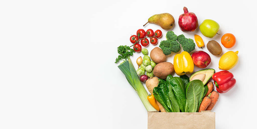 Sfondo di cibo sano.  Cibo sano in verdure e frutta in sacchetto di carta su bianco.  Consegna di cibo, concetto di supermercato alimentare
