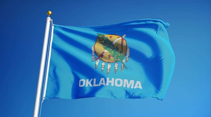 Bandiera dell'Oklahoma (stato degli Stati Uniti) che sventola contro il cielo azzurro, primo piano, isolato con tracciato di ritaglio maschera trasparenza del canale alfa, perfetto per film, notizie, composizione