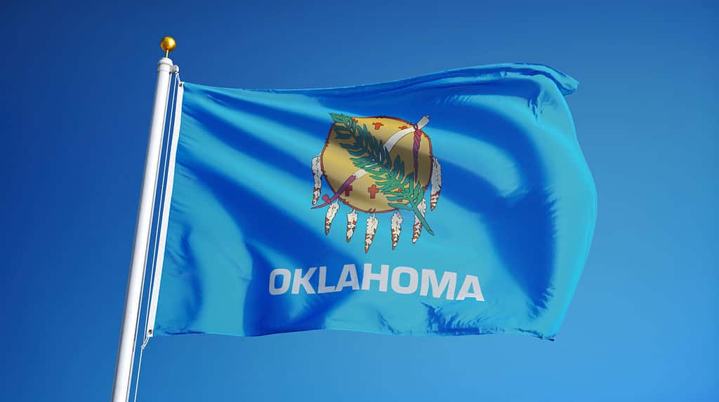 Bandiera dell'Oklahoma (stato degli Stati Uniti) che sventola contro il cielo azzurro, primo piano, isolato con tracciato di ritaglio maschera trasparenza del canale alfa, perfetto per film, notizie, composizione