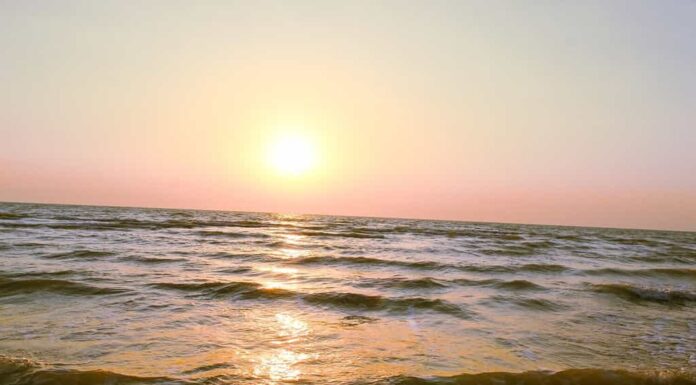 Bel tramonto estivo e il riflesso della luce solare sulle onde ruggenti delle acque dell'oceano, mare ruggente