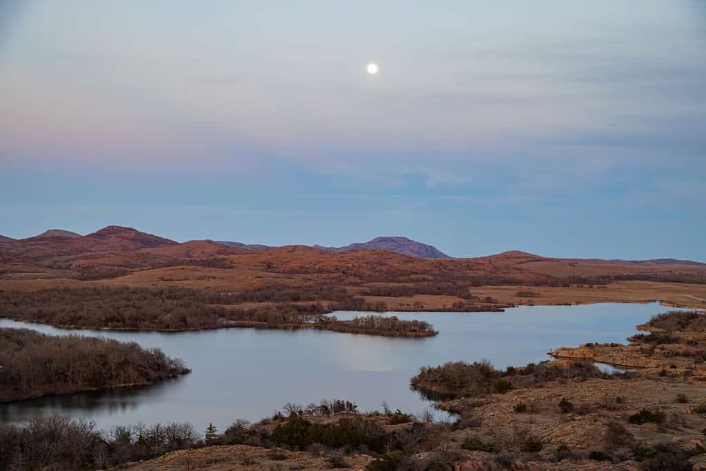 Paesaggio al tramonto con la luna piena nel Wichita Mountains National Wildlife Refuge in Oklahoma