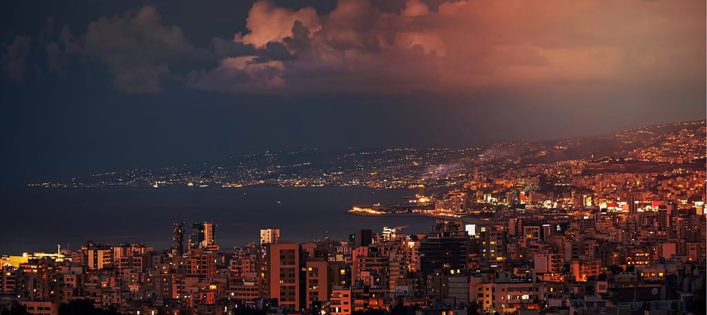 Bellissimo paesaggio notturno di una città costiera.  Case con finestre luminose nella luce della sera.  Splendida città di montagna.  Jounieh.  Libano.