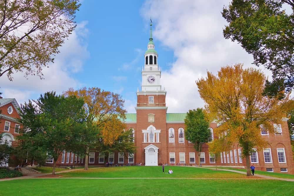 Guardando verso il basso il Dartmouth Green con gli alberi che iniziano a mostrare i colori autunnali e un cielo azzurro con nuvole bianche e gonfie in una bella giornata autunnale, la Biblioteca Baker e il suo campanile sono sullo sfondo.