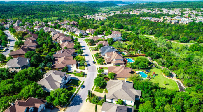 Vista aerea del drone sopra la strada curva con case di lusso del palazzo che conducono al paesaggio verde delle colline Cedar Park Texas Suburb