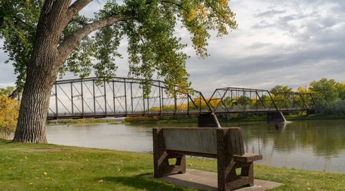 Fiume Missouri e ponte a Fort Benton Montana con panchina nel parco.