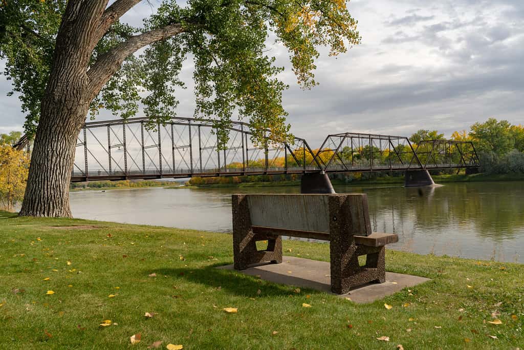 Fiume Missouri e ponte a Fort Benton Montana con panchina nel parco.