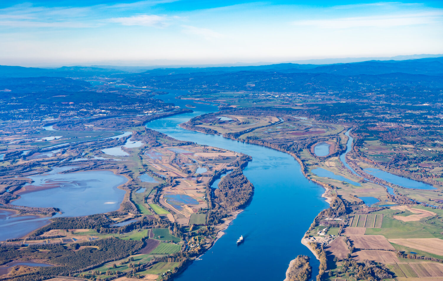 Veduta aerea della fattoria e dell'area faunistica dell'isola di Sauvie e del fiume Columbia che conduce a ovest verso Astoria, Oregon, da Vancouver, Washington