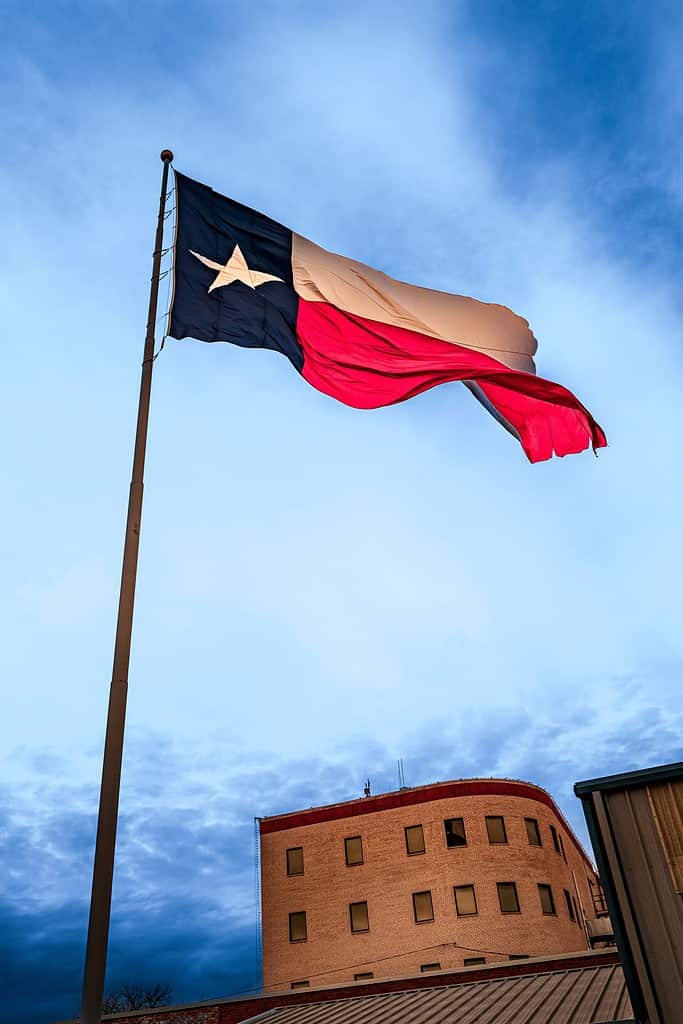 Lone Star Texas State Flag sventola nel vento su Odessa in Texas, USA, drammatico paesaggio nuvoloso
