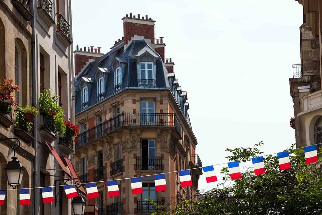 Strada parigina decorata con ghirlanda di bandiere francesi.  Parigi, Francia.  Concetto di celebrazione della festa nazionale.