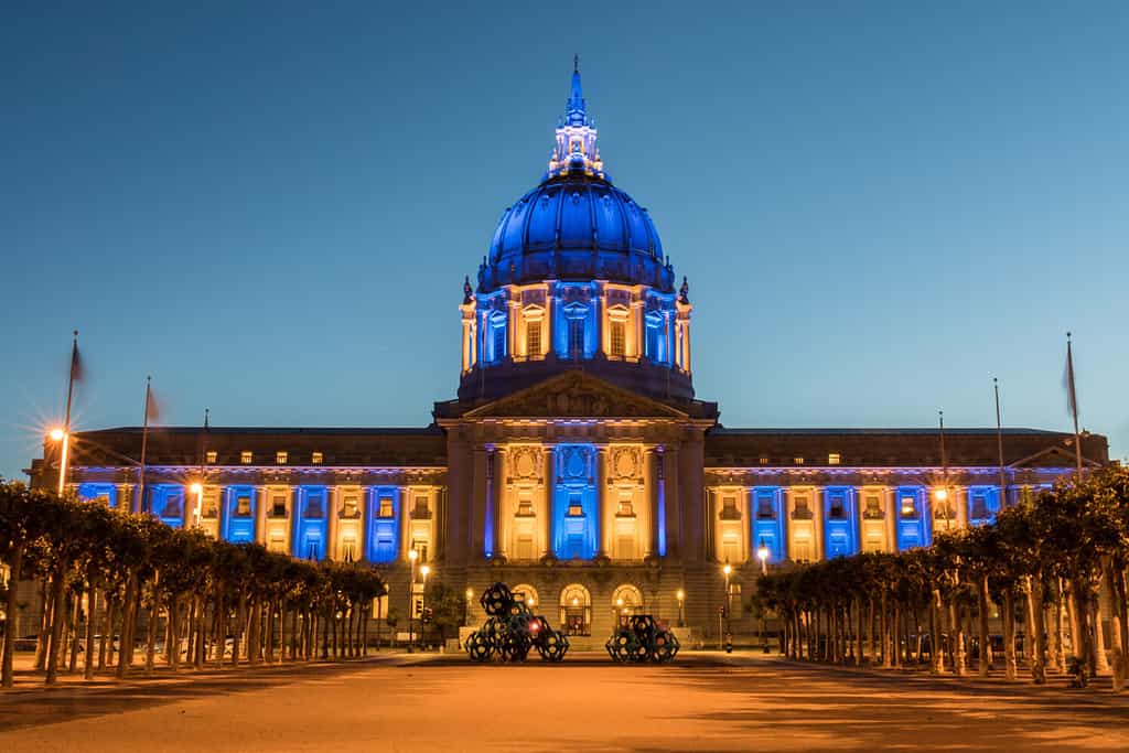 Il municipio di San Francisco è illuminato dai colori blu e giallo dei Golden State Warriors.  San Francisco, California, Stati Uniti.