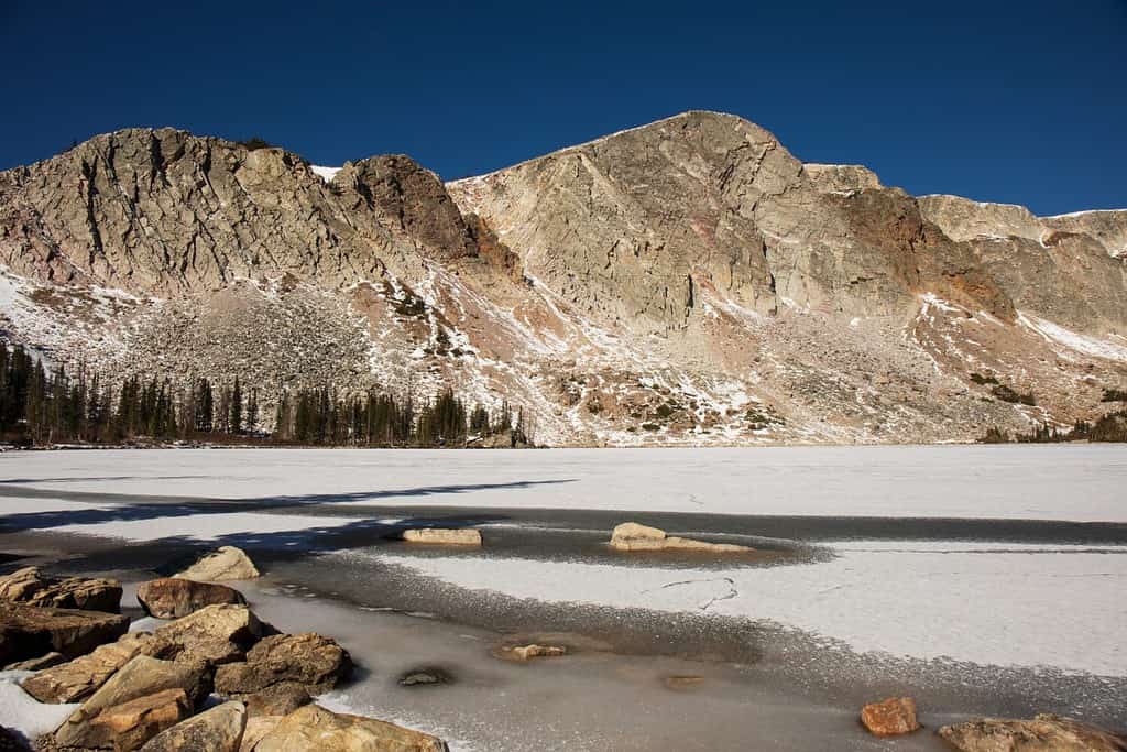 La catena montuosa innevata del Wyoming sudoccidentale all'inizio dell'inverno.  Parco nazionale di Medicine Bow-Routt.  Gamma innevata nel Medicine Bow Wilderness del Wyoming.  Massi, alberi, neve e pareti rocciose a strapiombo.