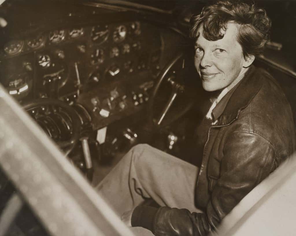 Amelia Earhart seduta nella cabina di pilotaggio del suo aereo Lockheed Electra, ca.  1936.