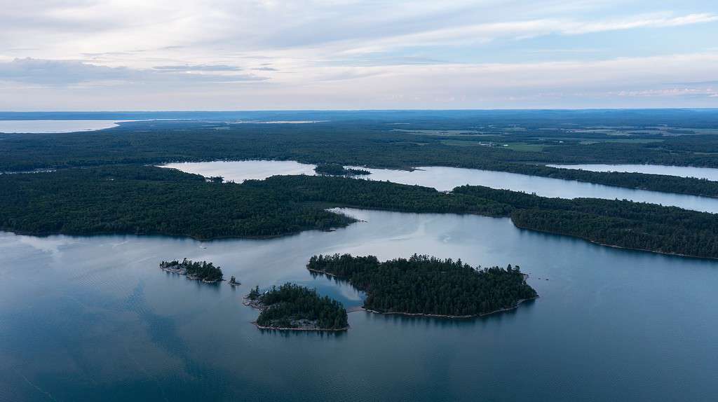 Vista aerea con drone del fiume St. Mary tra il Lago Superiore e il Lago Huron con canali d'acqua che attraversano paesaggi tra Canada e Stati Uniti d'America. Isole tra i paesi.