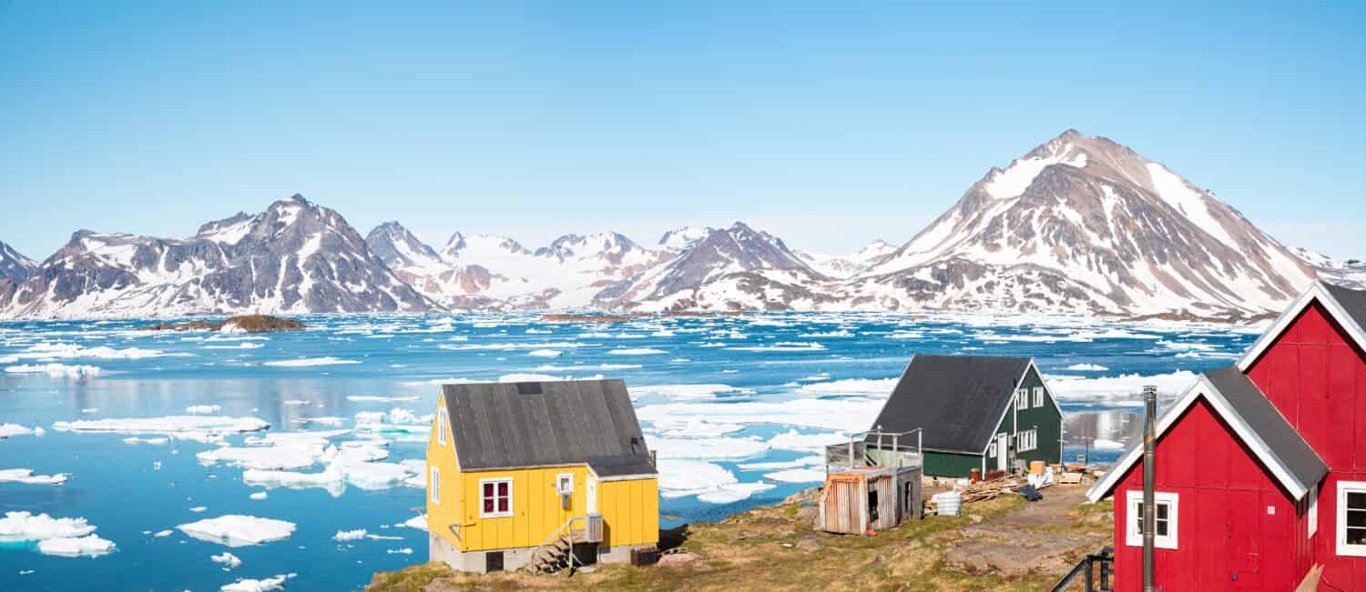 Vista panoramica del colorato villaggio di Kulusuk nella Groenlandia orientale - Kulusuk, Groenlandia - Scioglimento di un iceberg e versamento di acqua nel mare