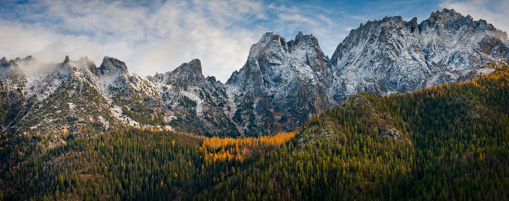 Washington Pass lungo la North Cascades Highway durante la stagione autunnale.  I larici e la neve sulle colline segnalano l'avvicinarsi dell'inverno nella catena montuosa North Cascade.