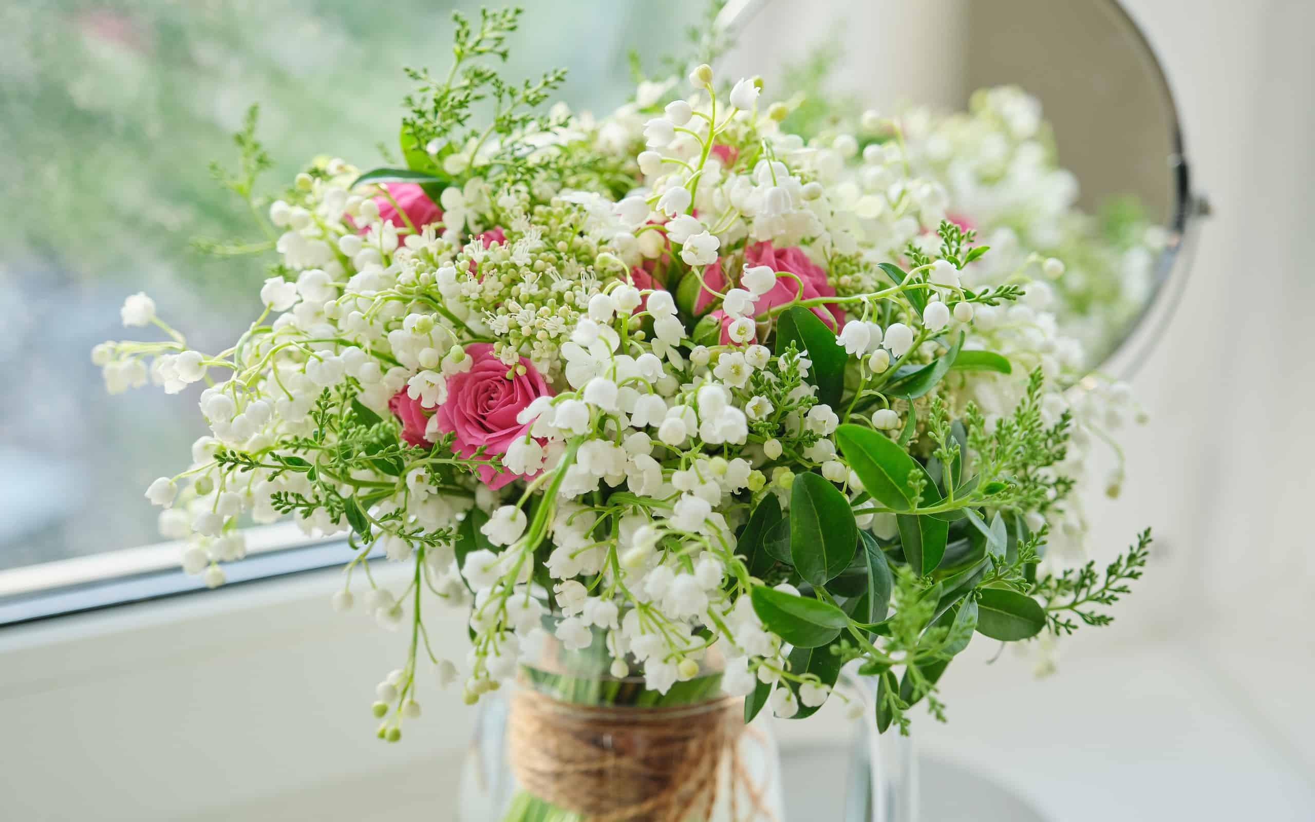 Primavera, profumo primaverile fresco di mughetti, rose rosa, viburno in fiore