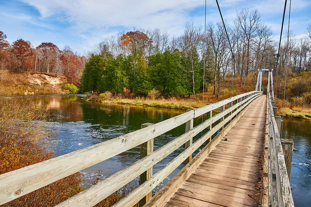 Ponte sospeso del Manistee River Trail nel tardo autunno su river.jpg