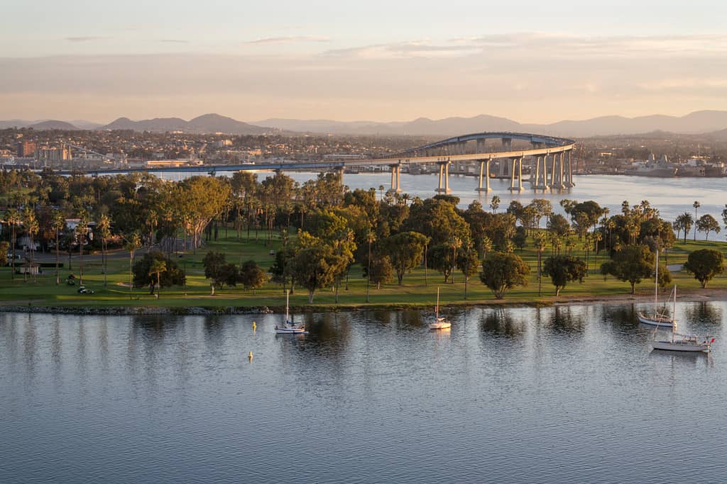 Alba di Coronado California.  L'alba arriva a Coronado Island rivelando la baia, il campo da golf, il villaggio e il ponte di Coronado.