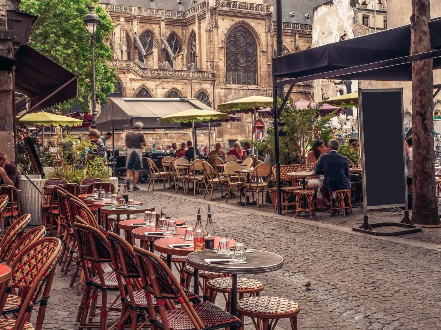 Strada accogliente con tavolini di un bar a Parigi, Francia.  Architettura e monumenti di Parigi.  Cartolina di Parigi