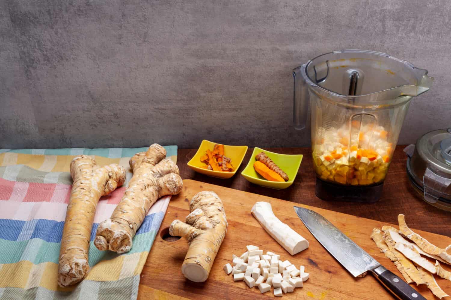 Preparare la salsa al rafano e curcuma utilizzando la tazza del mixer.  Radici crude di rafano e curcuma.