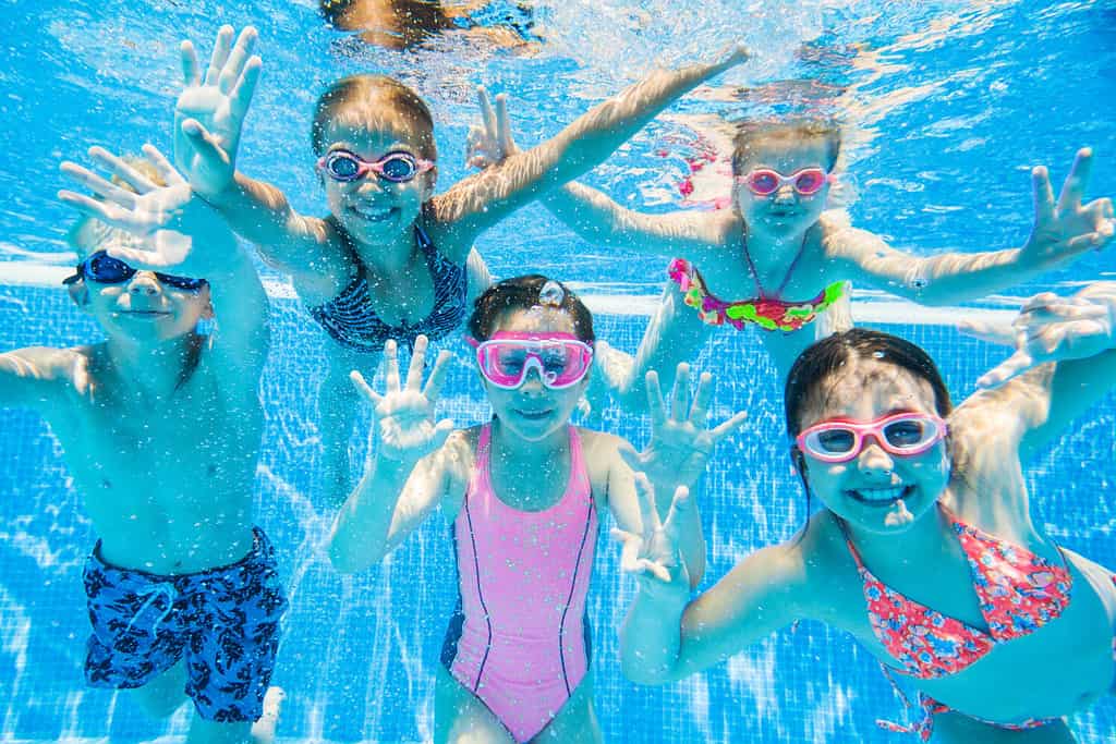 bambini piccoli che nuotano in piscina sott'acqua.