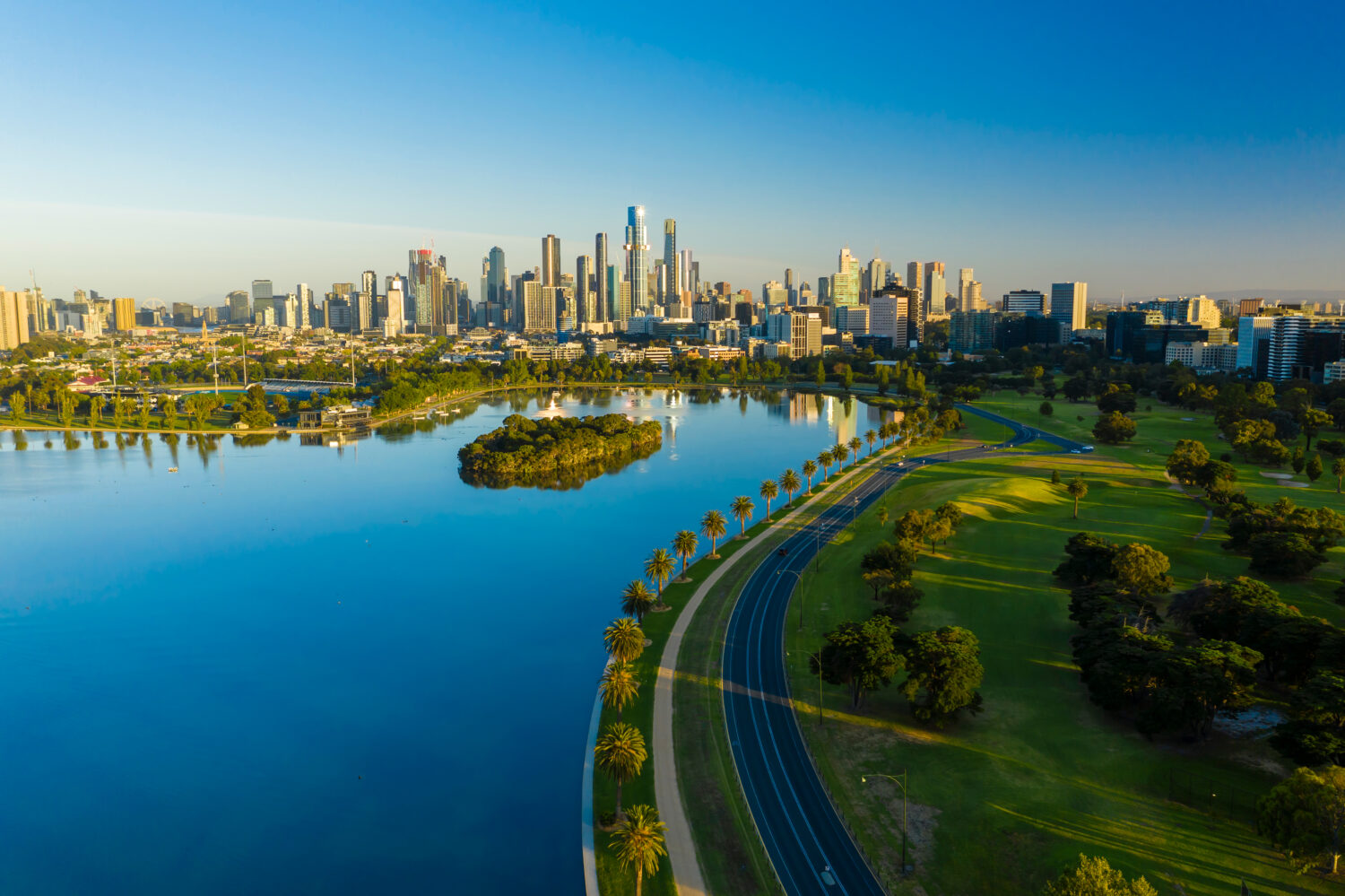 Foto aerea del bellissimo parco con lago e CBD di Melbourne all'alba