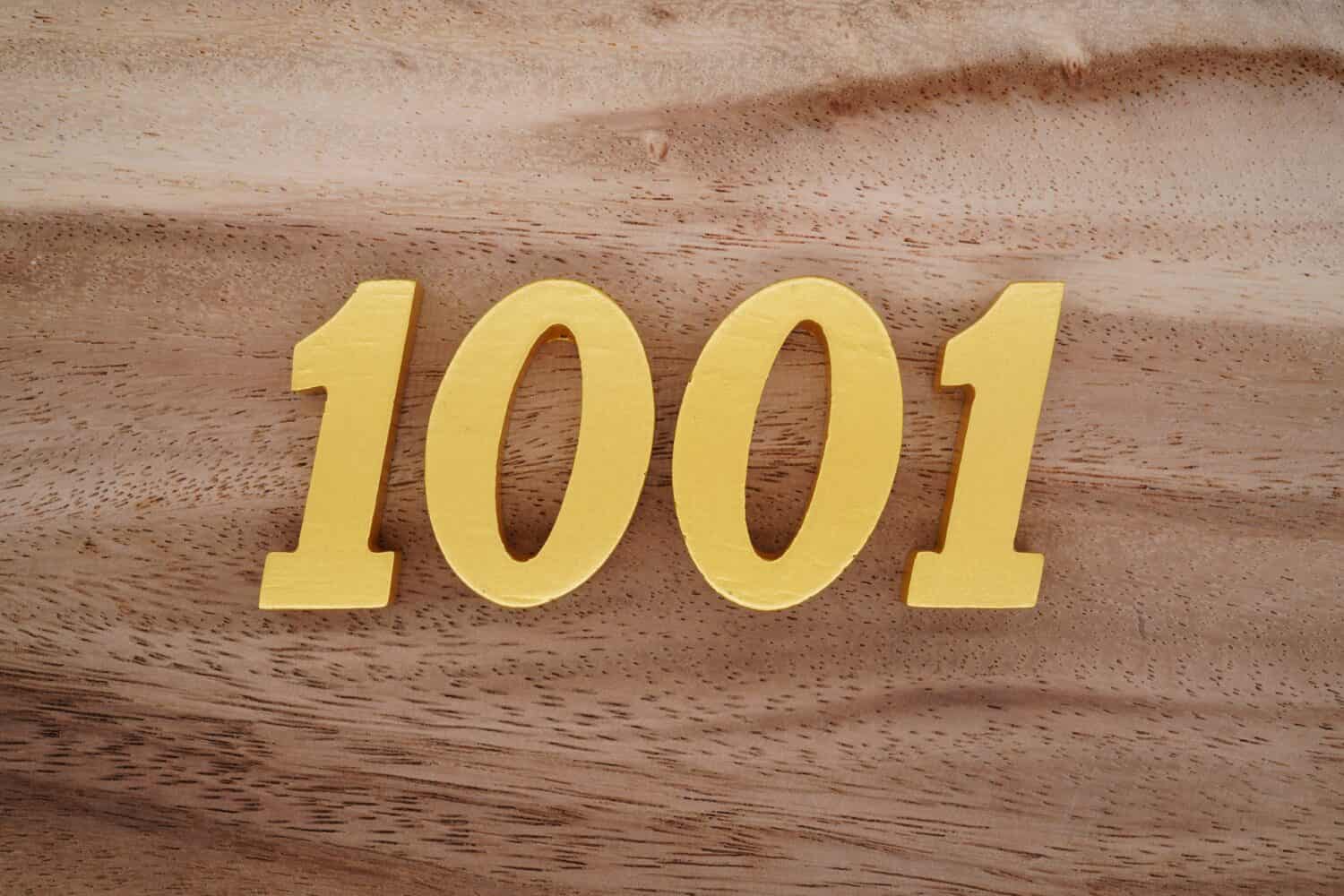 Numeri in legno 1001 dipinti in oro su uno sfondo a listoni con motivi marrone scuro e bianco.