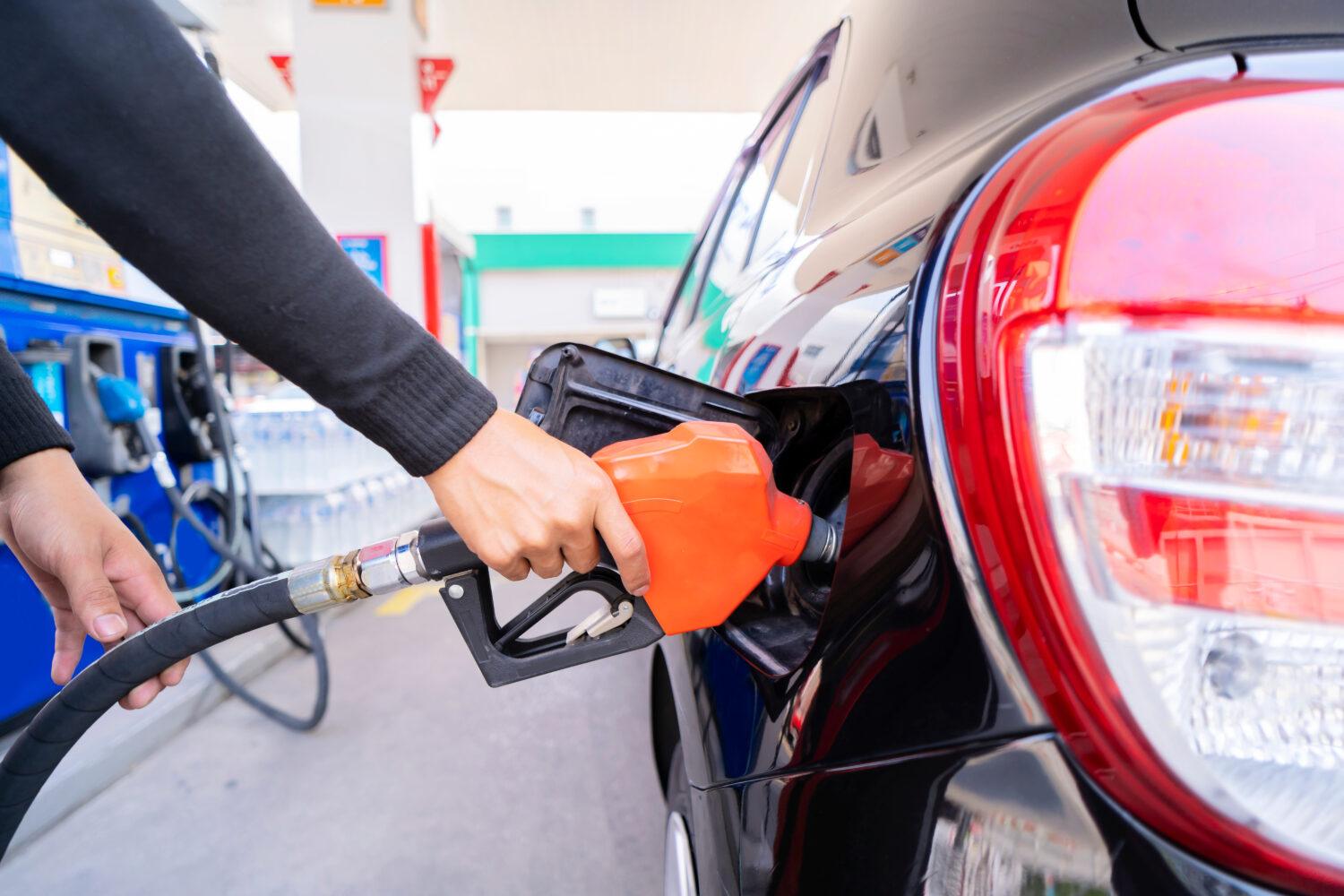 Fai rifornimento alle auto alla pompa di benzina.  L'autista consegna, fa rifornimento e pompa la benzina dell'auto con carburante presso la stazione di servizio.  Rifornimento di auto presso una stazione di servizio Stazione di servizio