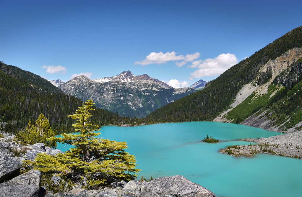 Un bellissimo lago glaciale in Canada.  Il turchese lago Joffre è circondato dalla foresta pluviale.  Cime delle montagne sullo sfondo.  Parco provinciale dei laghi Joffre.  Columbia Britannica, Canada.