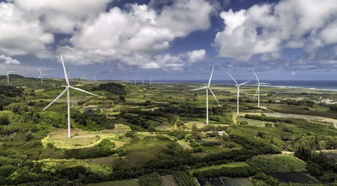 Turbine eoliche nel parco eolico di Kahuku a Oahu, Hawaii.  Cielo blu soleggiato con nuvole bianche