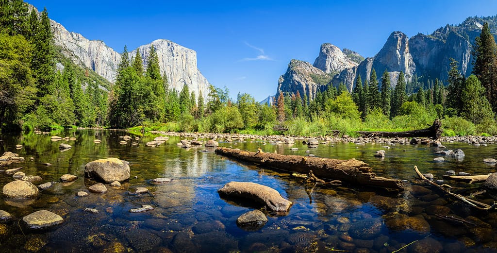 Vista panoramica panoramica della famosa Yosemite Valley con la cima di arrampicata su roccia El Capitan e l'idilliaco fiume Merced in una bella giornata di sole con cielo azzurro in estate, Parco nazionale Yosemite, California, Stati Uniti