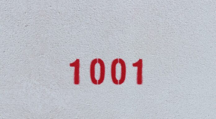 Numero rosso 1001 sul muro bianco.  Vernice spray.