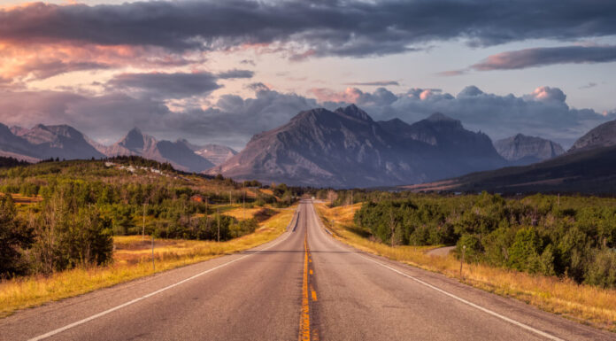 Bellissima vista della Scenic Highway con il paesaggio delle montagne rocciose americane sullo sfondo.  Cielo colorato di alba estiva.  Preso a St Mary, Montana, Stati Uniti.