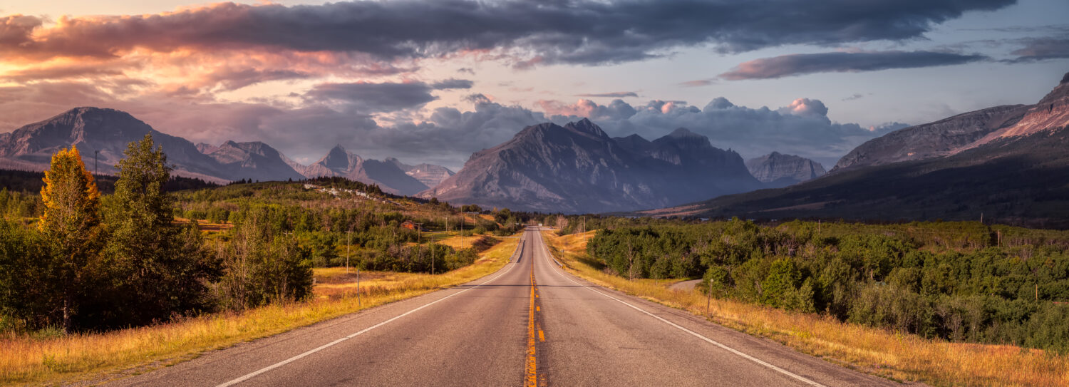 Bellissima vista della Scenic Highway con il paesaggio delle montagne rocciose americane sullo sfondo.  Cielo colorato di alba estiva.  Preso a St Mary, Montana, Stati Uniti.