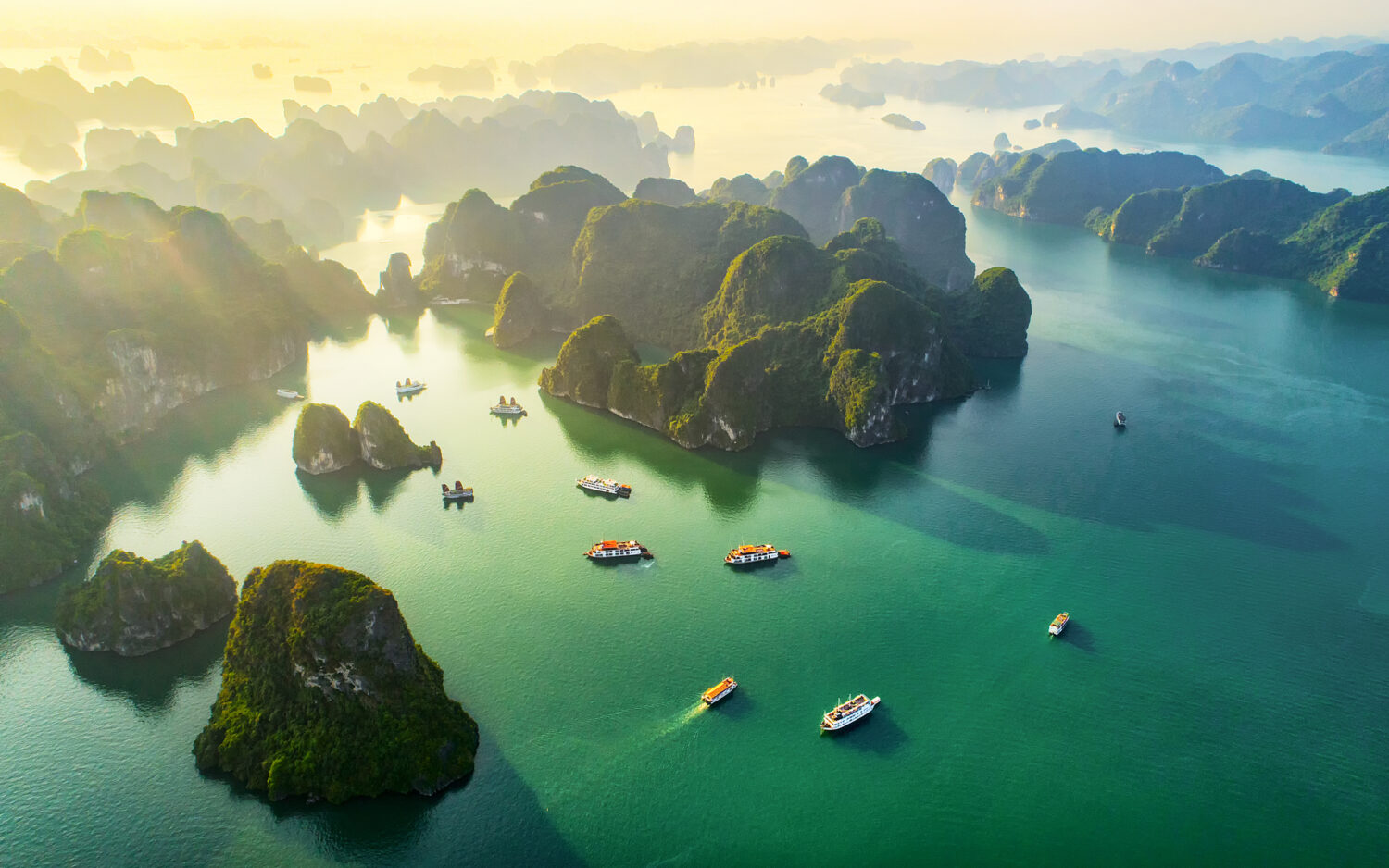 Vista aerea villaggio di pescatori galleggiante e isola rocciosa, baia di Halong, Vietnam, sud-est asiatico.  Sito Patrimonio dell'Umanità dell'UNESCO.  Crociera in barca spazzatura alla baia di Ha Long.  Punto di riferimento popolare, famosa destinazione del Vietnam