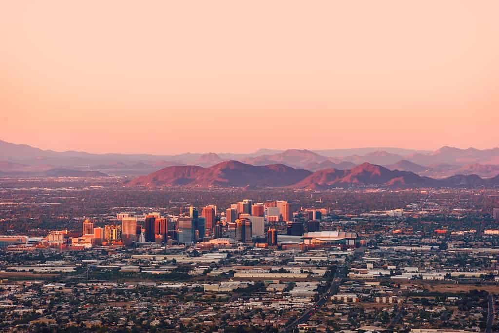 Phoenix Arizona con il suo centro illuminato dagli ultimi raggi di sole al tramonto.