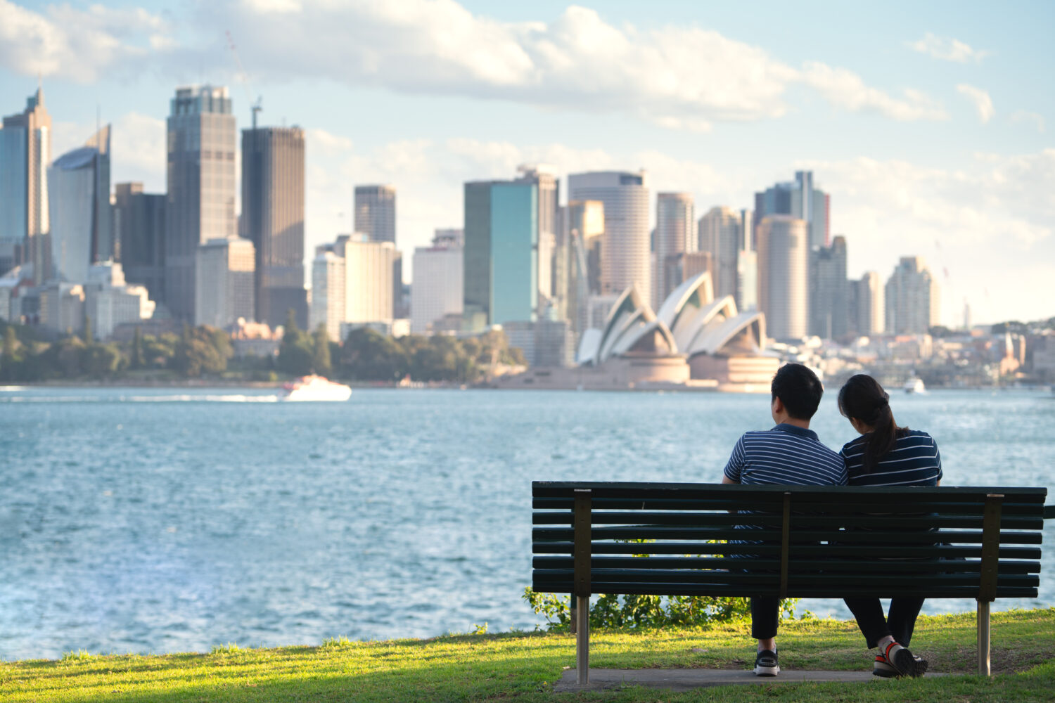 Una coppia asiatica si siede e si rilassa dopo aver corso in un parco a Sydney, in Australia