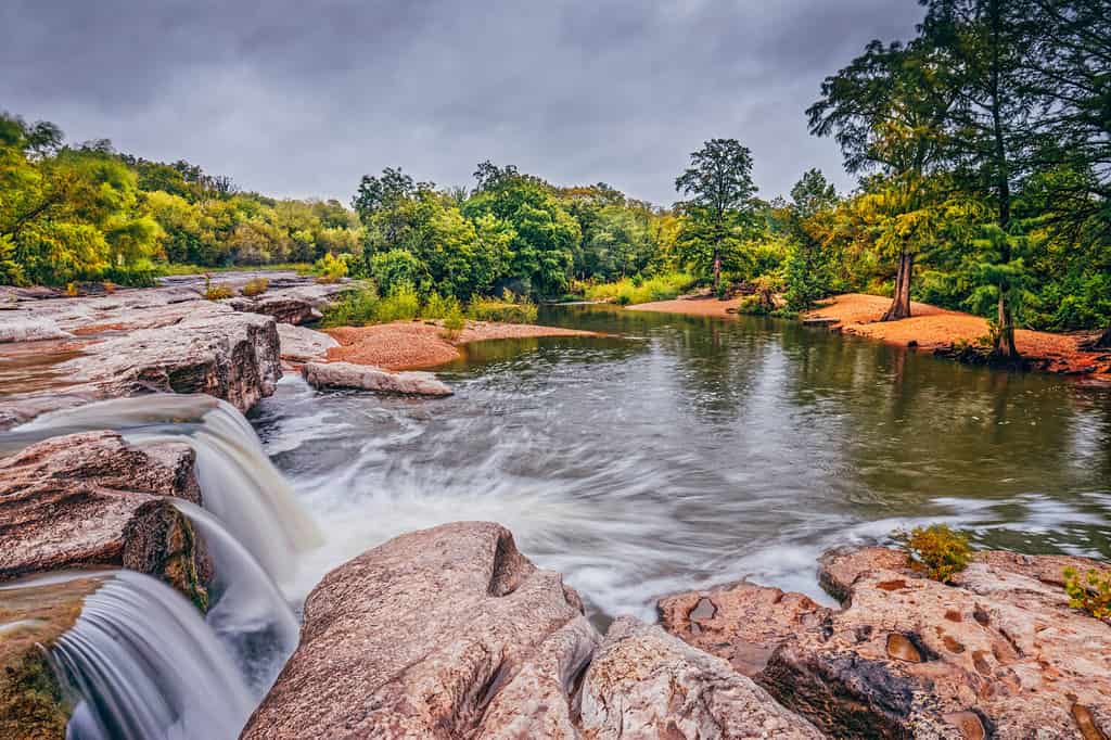 Onion Creek che si rovescia sulla sporgenza di calcare alle cascate inferiori McKinney Falls State Park Austin Texas