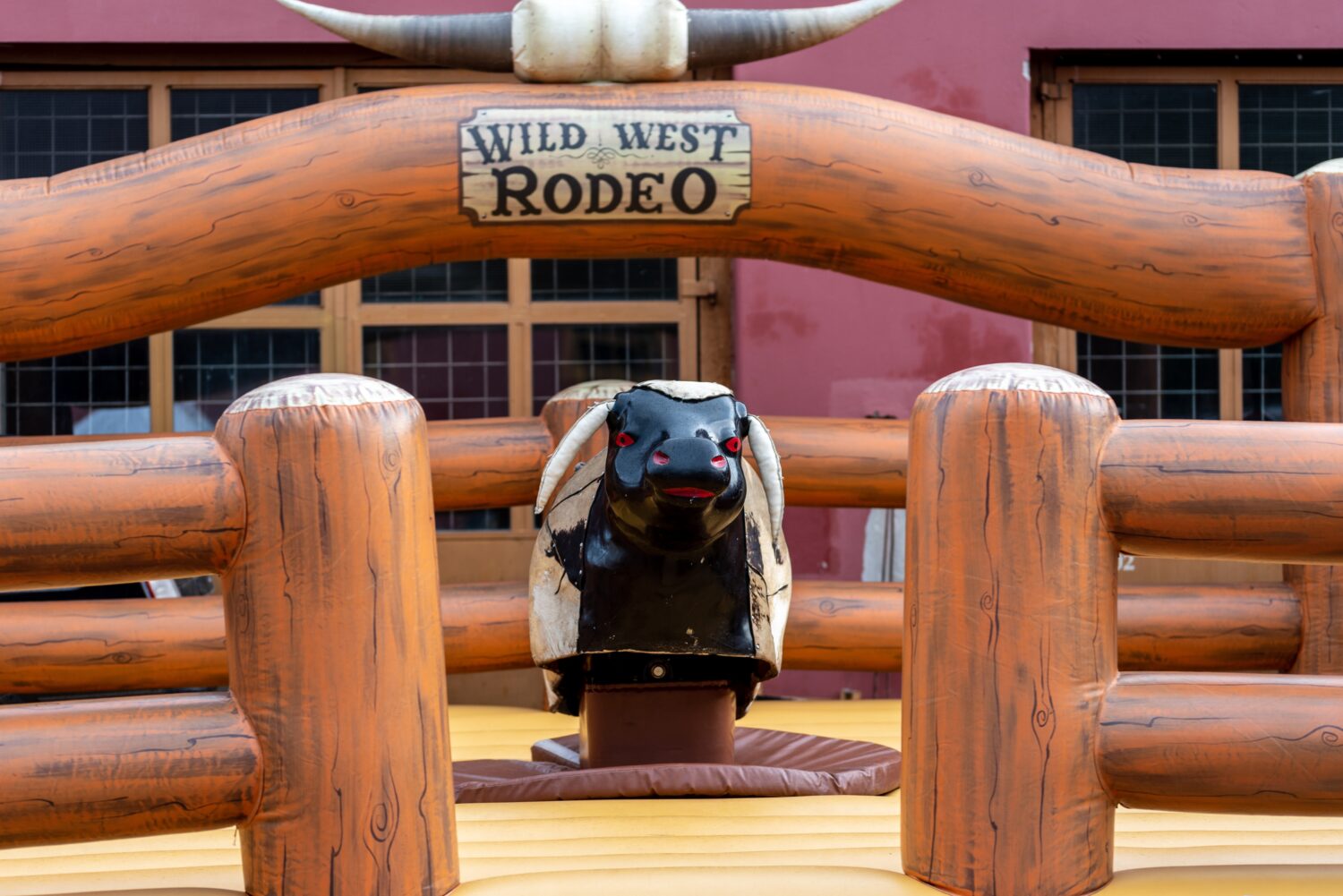 Grande macchina meccanica da rodeo per cavalcare un toro in legno.